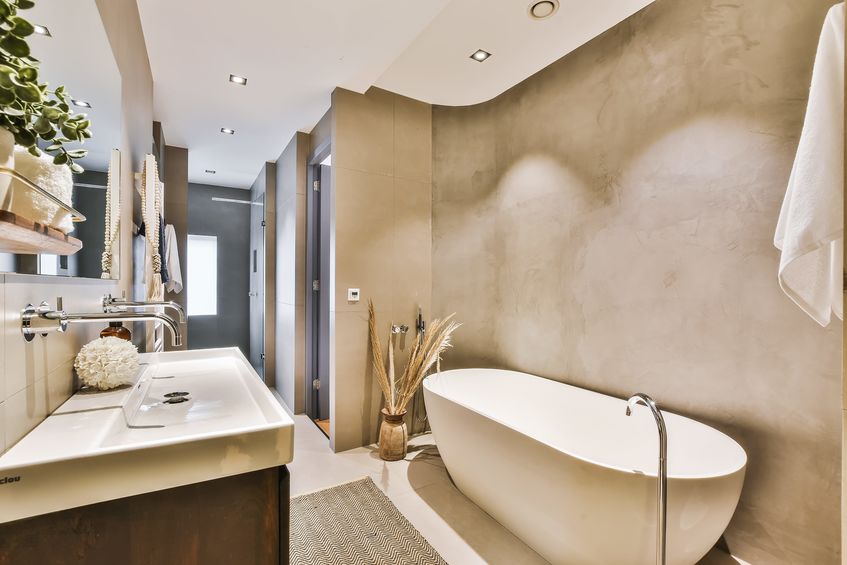 Luxury bathroom with a bath against the wall and a counter and sunk on the other side of it